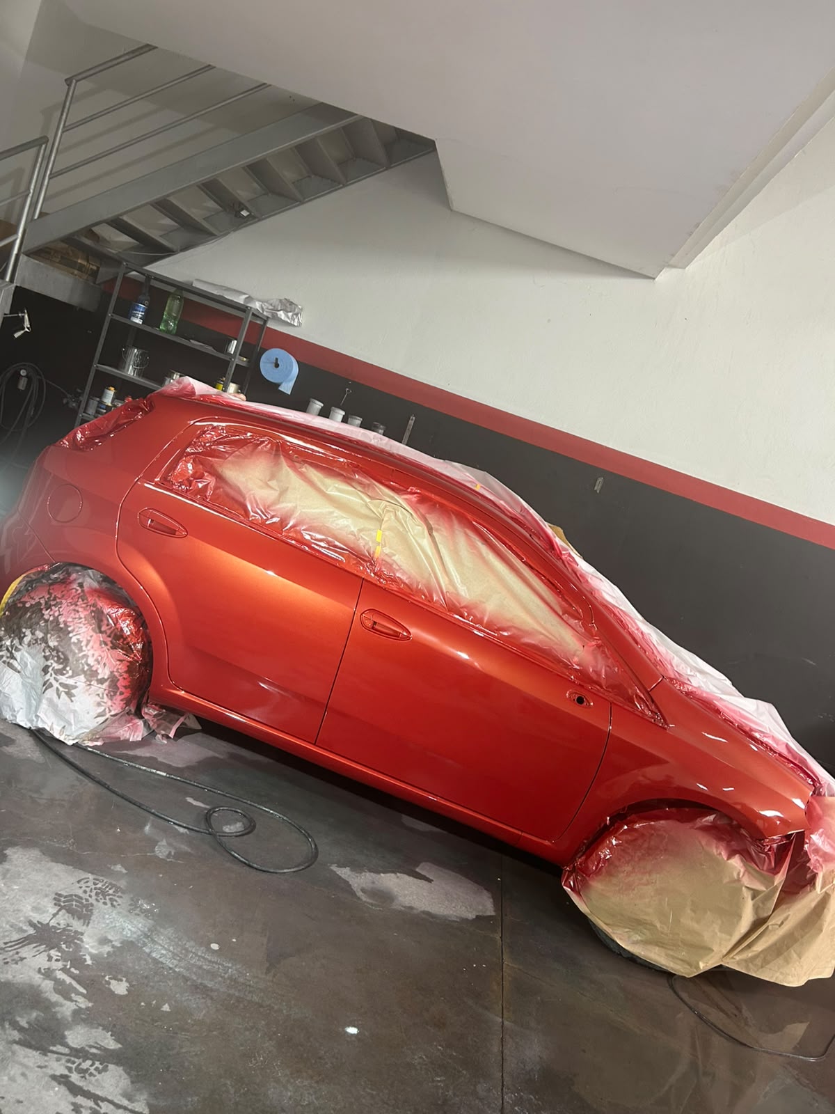 Carro vermelho mascarado em preparação para pintura