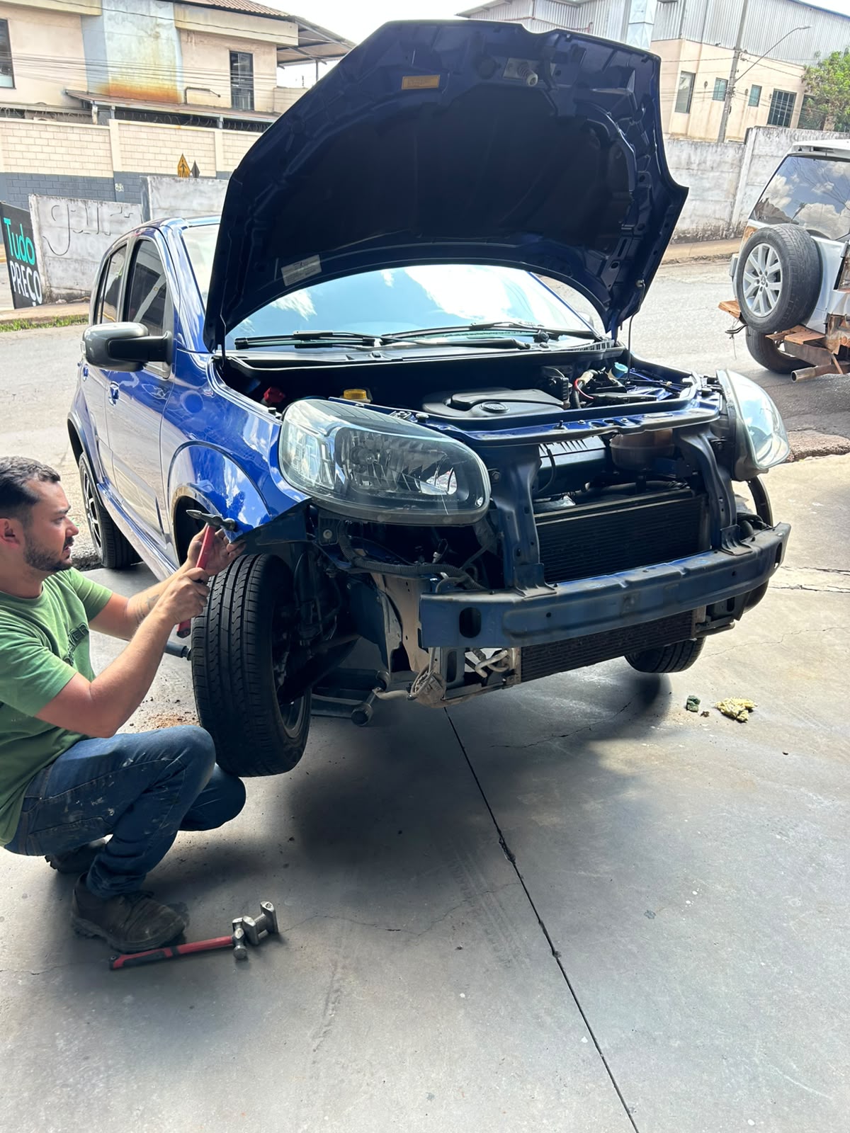 Funilaria na parte frontal de um carro azul