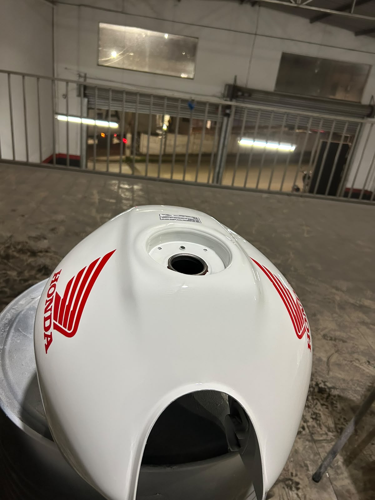 Tanque de moto Honda pintado de branco com detalhes vermelhos